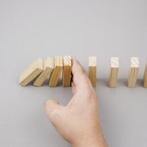 formation conduite du changement on voit quelqu'un qui arrête les dominos en train de tomber